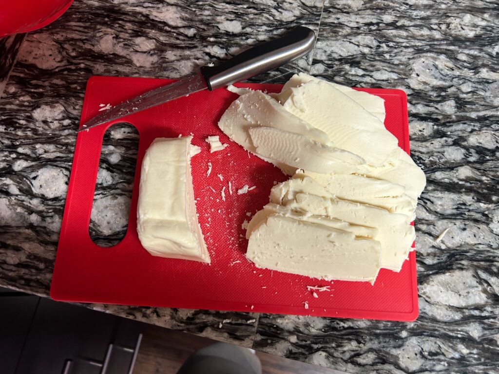 Cheese cut into thin slices while waiting for water to boil