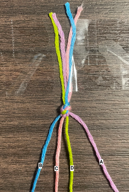 This is the photo of the first complete stripe. The 3 knots made with the A string are complete. This is how the bracelet will look prior to completing step 8.